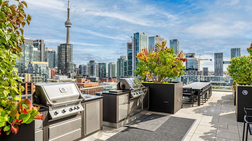 Two stainless barbecues on the rooftop terrace with the CN Tower and skyline in the background